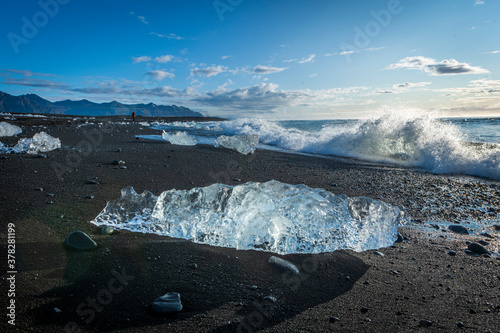 Glacial iceberg on black sand beach at Sunrise, Iceland photo