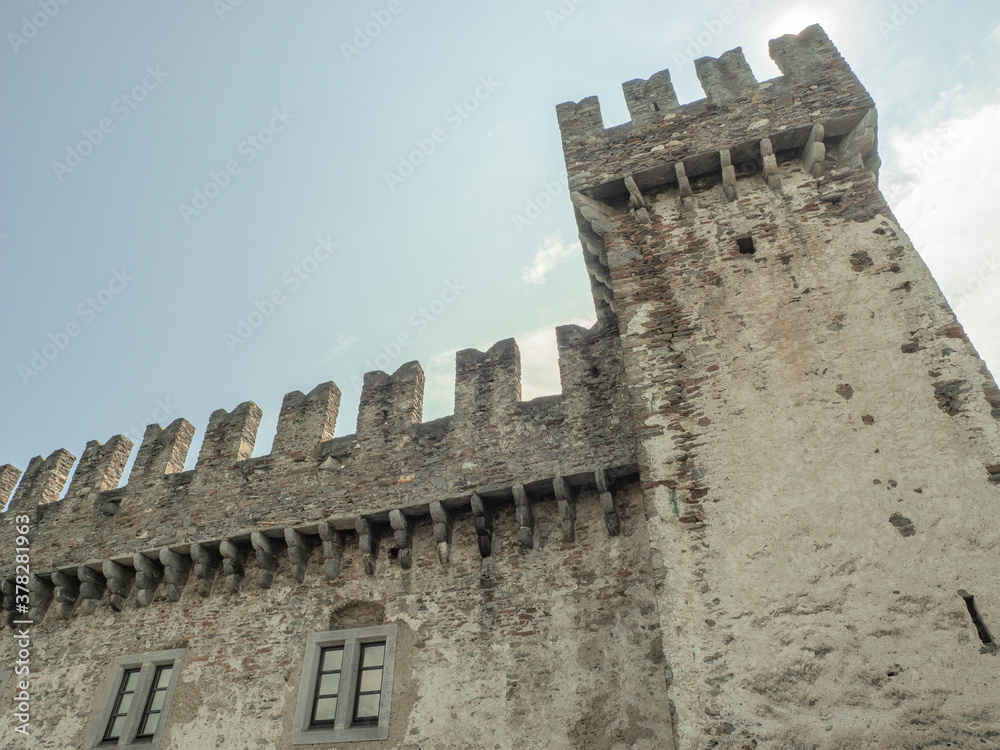 defensive tower of the old Italian castle with battlements that protect the perimeter walls