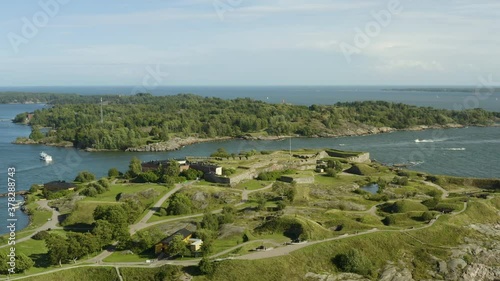 Aerial view overlooking the Kustaanmiekka island, at the Suomenlinna fortress, Vallisaari in the background, sunny, summer day, in Helsinki, Finland - dolly, drone shot photo