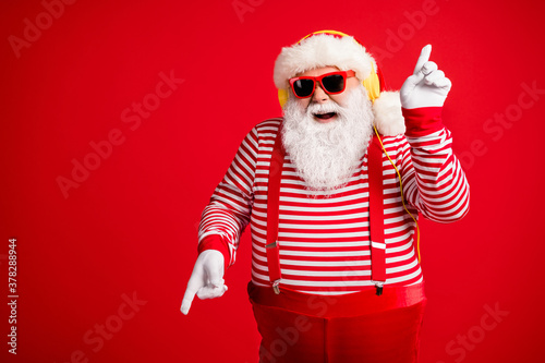 Portrait of his he handsome bearded fat overweight cheerful cheery glad Santa meloman listen single hit sound rest dancing having fun isolated bright vivid shine vibrant red color background © deagreez