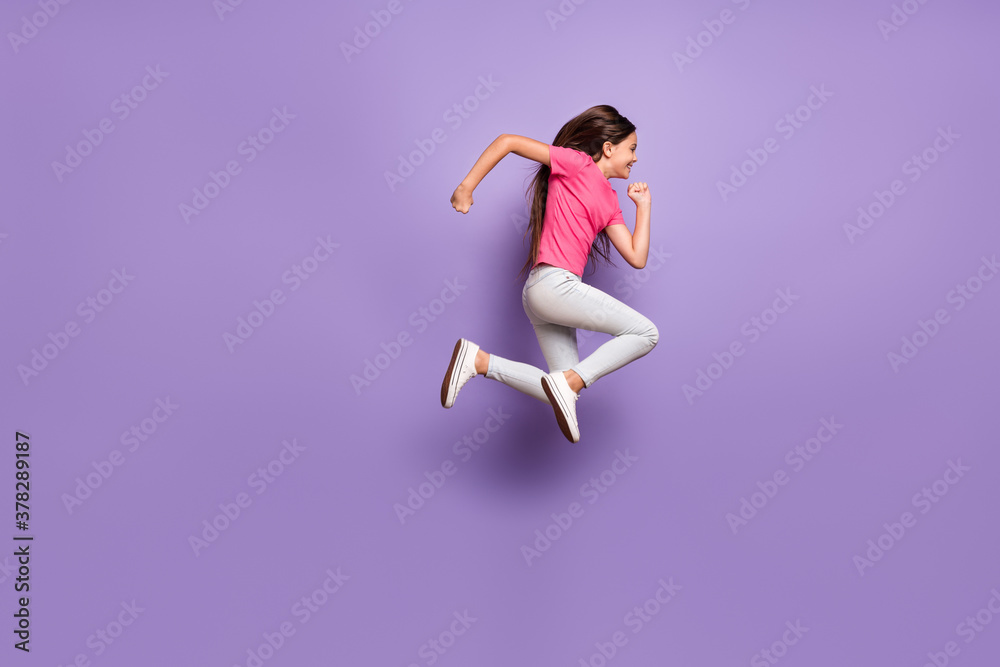 Full length body size side profile photo of jumping high pretty schoolgirl running fast isolated on purple color background