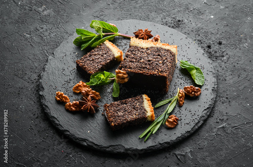 Poppy seed cake with chocolate and nuts. Dessert. On a black background. Top view. photo