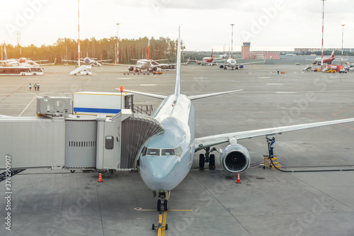 Photo Commercial passenger airplane in the parking at the airport terminal with a nose forward and a gangway