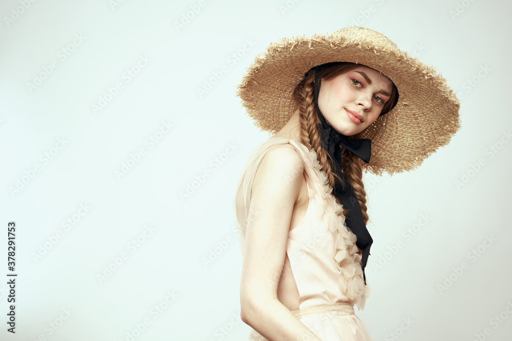 Nice girl in a straw hat with a black ribbon and in a dress on a light background romance model fun emotion Nice girl in a straw hat with a black ribbon and in a dress on a light background romance model fun emotion