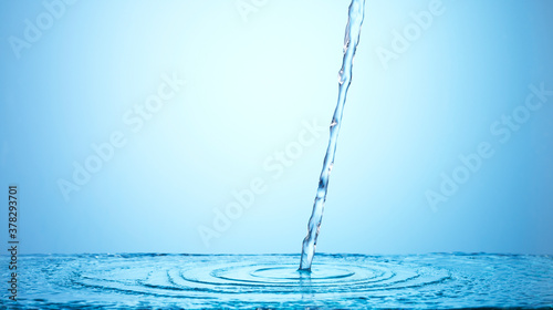 Pouring water on blue background