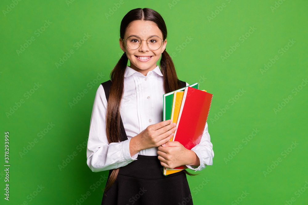 Photo of cute charming little lady in front of blackboard hold pile copybook toothy beaming smile prepare homework a-student wear white shirt glasses isolated green color background Photo of cute charming little lady in front of blackboard hold pile copybook toothy beaming smile prepare homework a-student wear white shirt glasses isolated green color background