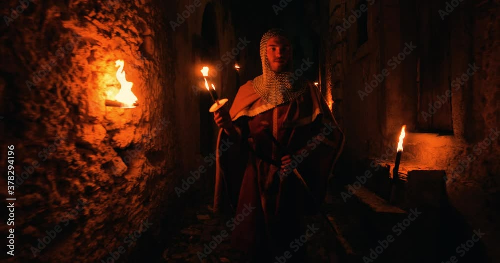 Normanno cammina per le strade della sua città tra le mura con la fiaccola in mano