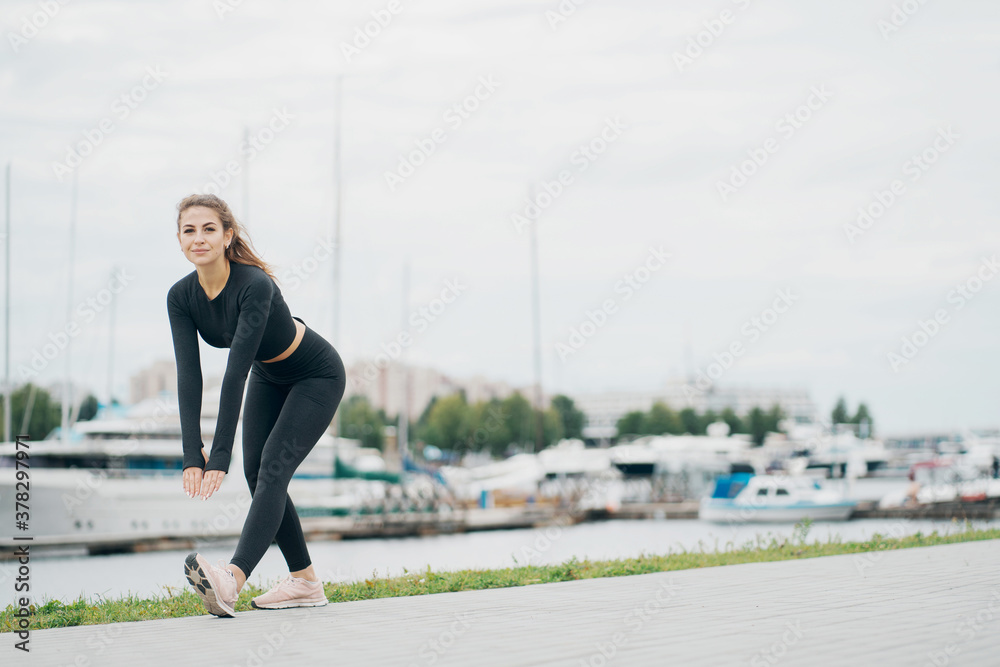 does forward leaning exercises aerobics healthy lifestyle. stylish tight comfortable clothing. portrait of a beautiful athletic brunette woman of Caucasian appearance.