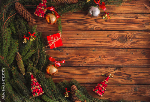 Christmas flat lay concept with new year 2021 bells and balls with red ribbon toys and pine strobile tree branches on brown wooden background. Copy space, top view overhead. photo