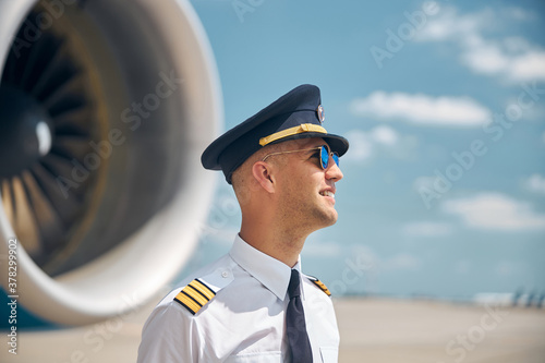 Foto Cheerful pilot in sunglasses standing outdoors in airfield