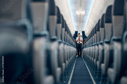 Empty blue colored salon of aircraft with cozy chairs
