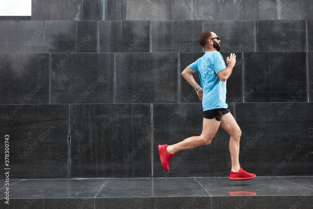 Modern sporty man jogging / exercise in urban environment.