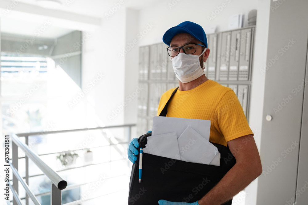 Mailman delivering mail with mail-bag and protective mask and gloves during virus pandemic. Mailman delivering mail with mail-bag and protective mask and gloves during virus pandemic.