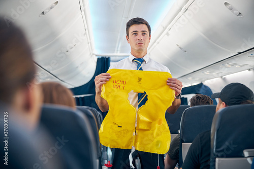 Steward demonstrating airplane rules for safety on board photo