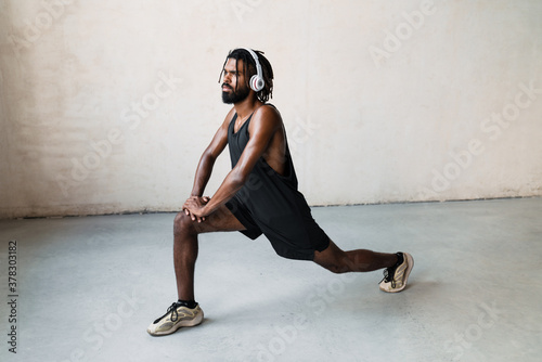 Fototapeta Naklejka Na Ścianę i Meble -  Image of african american sportsman doing exercise while working out