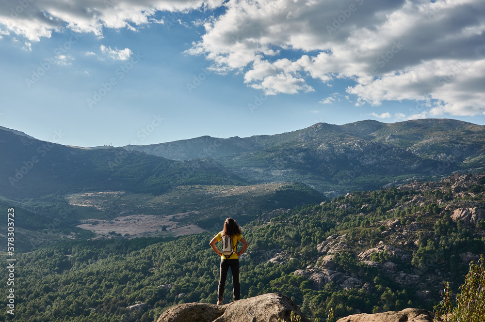 A mountaineer contemplates La Pedriza from the top of a rock in the Sierra de Guadarrama National Park. Madrid's community. Spain.