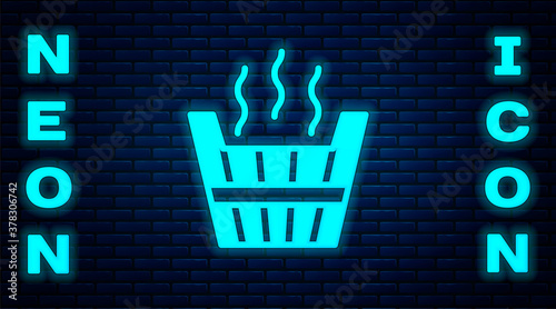 Glowing neon Sauna bucket icon isolated on brick wall background. Vector.