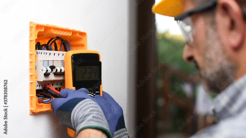 Electrician at work with the tester measures the voltage in the electrical panel of a residential installation. Construction industry. Footage.