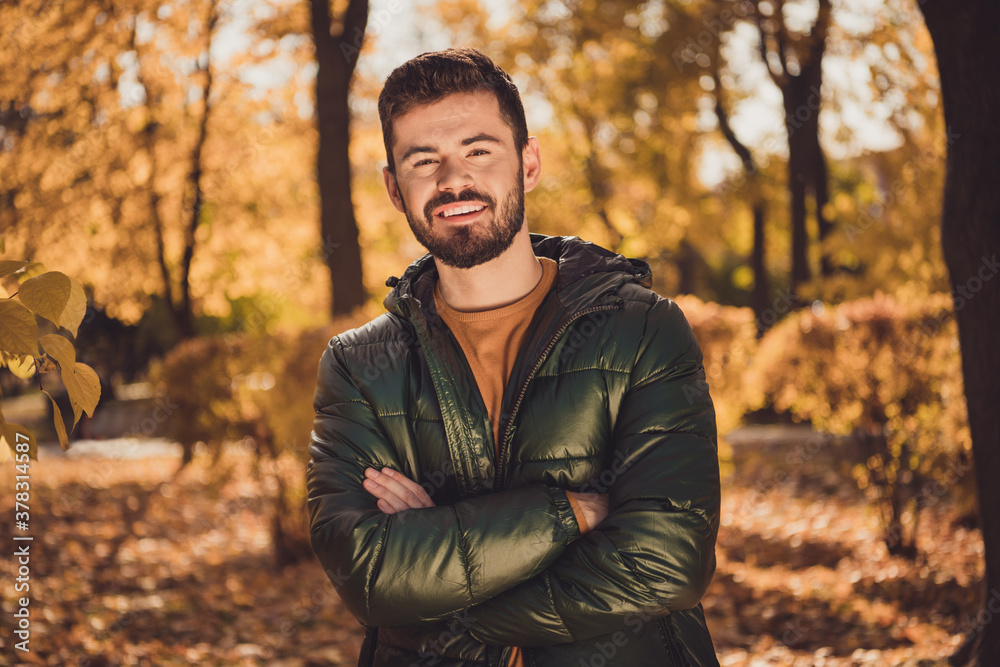 Portrait of attractive positive guy cross hands in autumn park outside town center Portrait of attractive positive guy cross hands in autumn park outside town center
