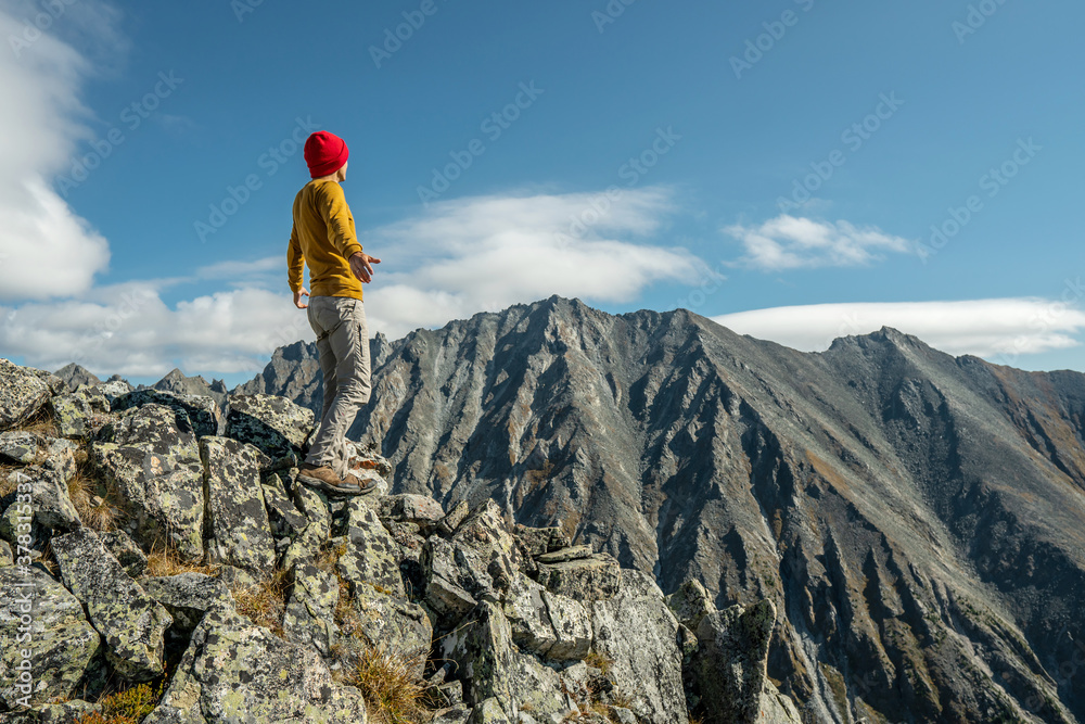 Tourist celebrate success by spreading their arms standing on background of mountains. Motivation and achievement
