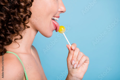 Close up cropped profile side photo of nice satisfied lady girl lick tongue lollipop loom copyspace wear green singlet tank-top isolated over blue color background