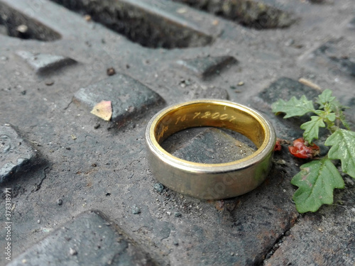 Wedding ring on the street in front of a manhole or drain