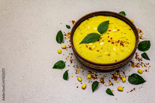 Corn cream soup with fresh vegetables, herbs and spices