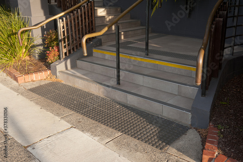 Details of railing and stairs of a modern building. Sidewalk guides for blind. 