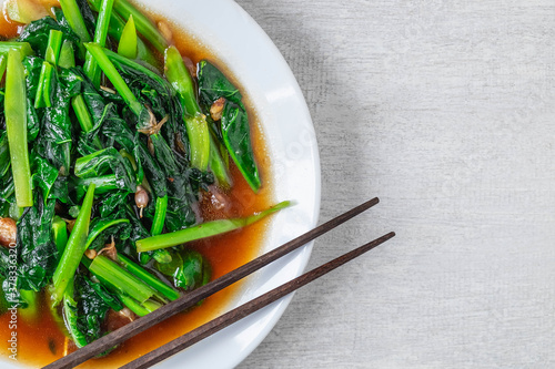 Fried Kale with Oyster Sauce menu on wooden table photo