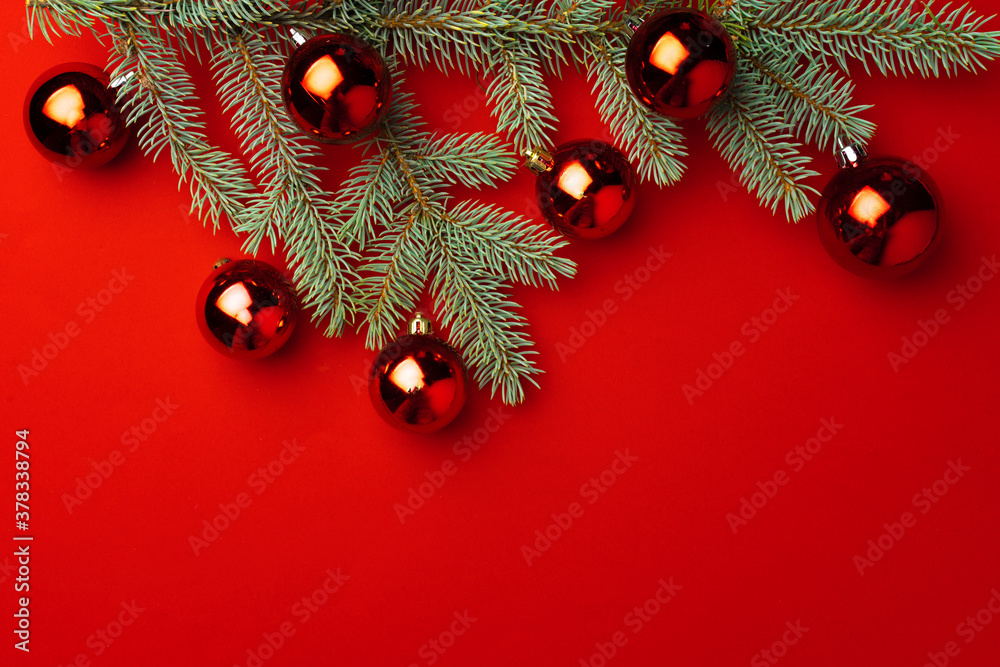 Christmas background with fir branches and balls on red