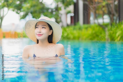 Portrait beautiful young asian woman relax enjoy smile around outdoor swimming pool