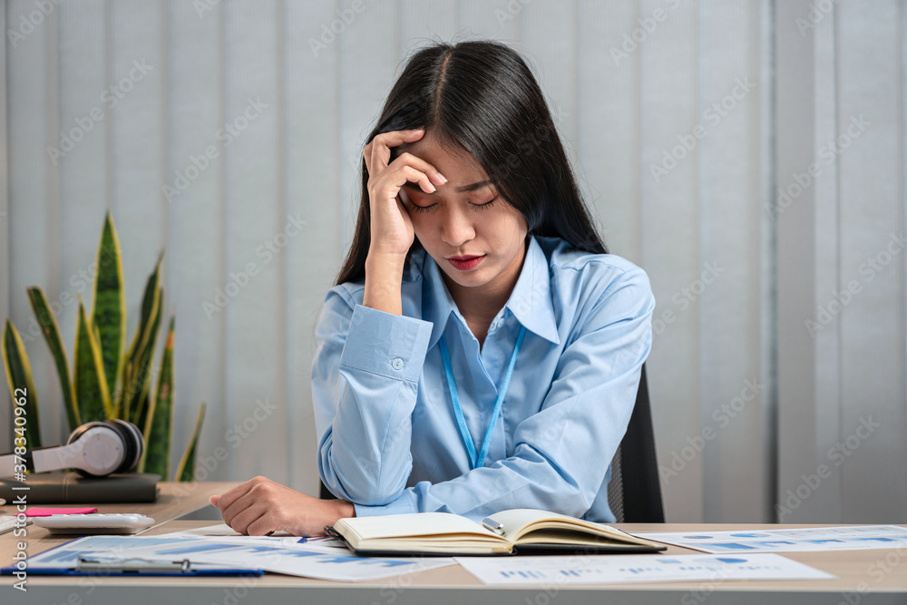 Portrait of young asian business woman feeling stress and tired from work sitting on the chair about constant headaches a migraine of working hard at office Portrait of young asian business woman feeling stress and tired from work sitting on the chair about constant headaches a migraine of working hard at office