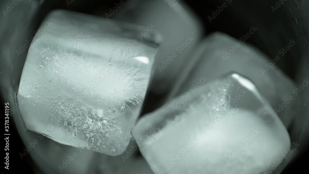 Yellow Drink Being Poured in Glass full of Ice Cubes Slow Motion Close Up Yellow Drink Being Poured in Glass full of Ice Cubes Slow Motion Close Up