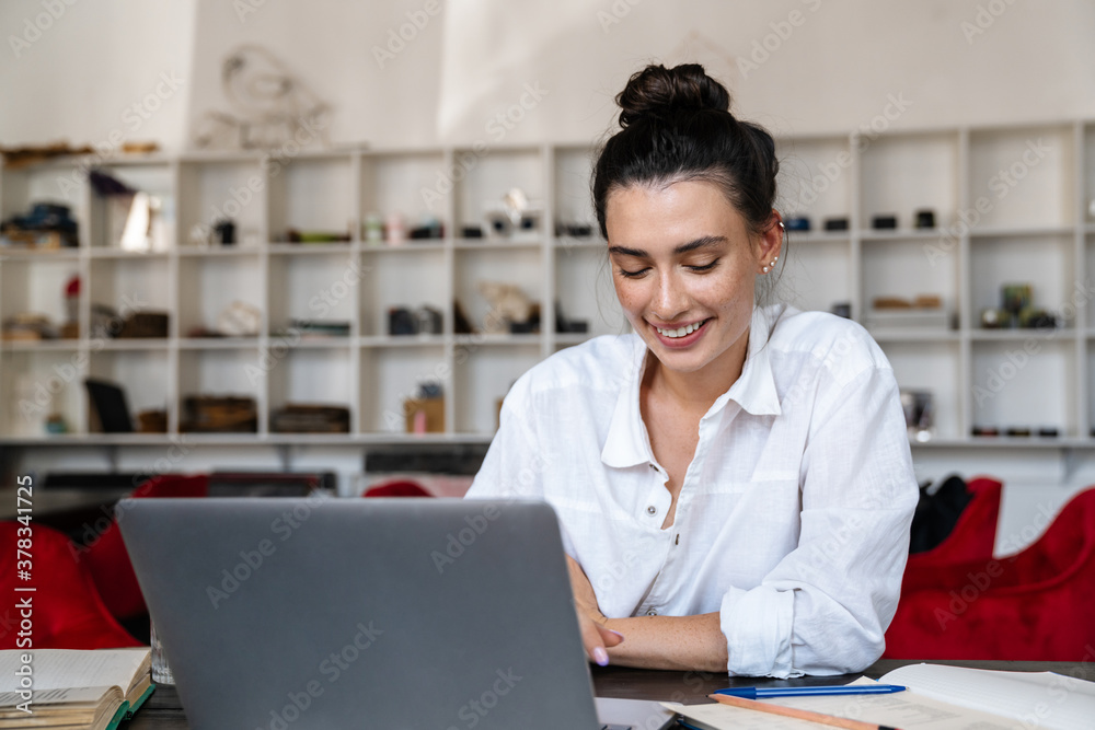 Smiling young woman studying on laptop computer Smiling young woman studying on laptop computer