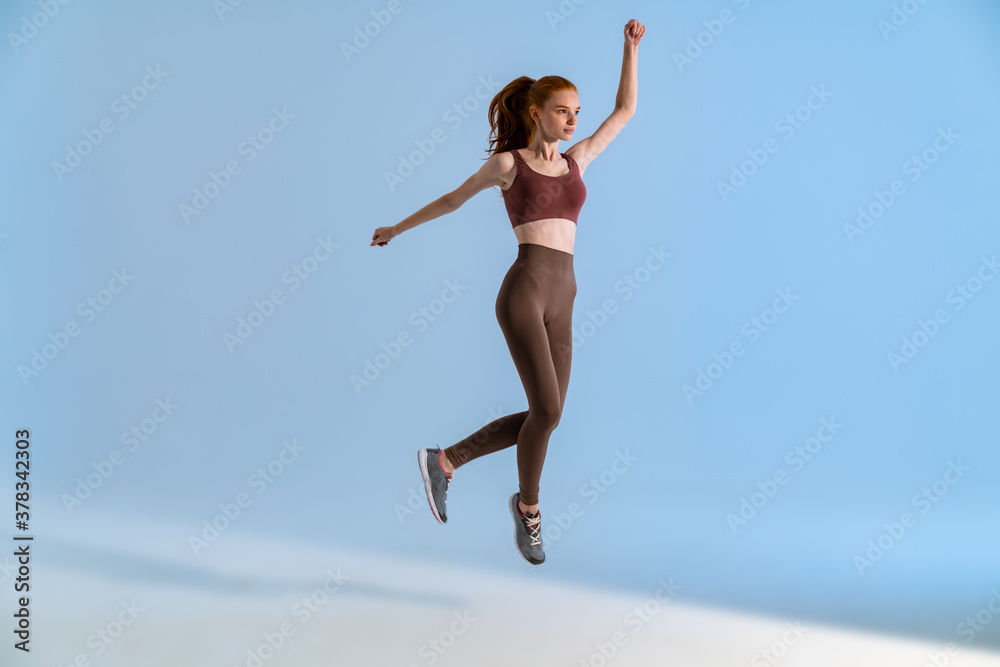 Photo of athletic focused sportswoman jumping while working out Photo of athletic focused sportswoman jumping while working out