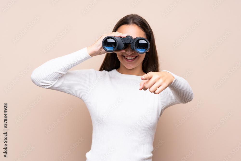 Young woman over isolated background with black binoculars
