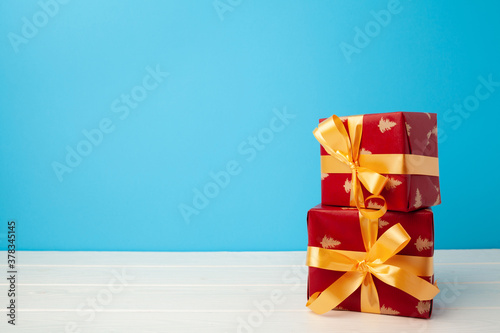 Several stacked Christmas gifts in festive wrapping