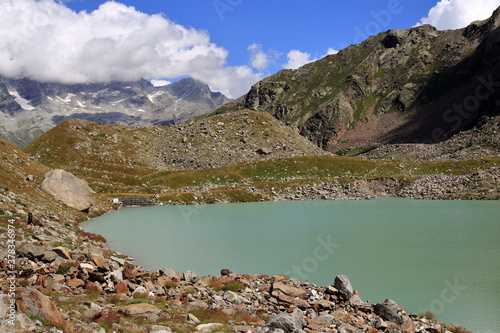 Lago delle Locce  Monte Rosa  sopra Macugnaga con acqua  montagne e nuvole