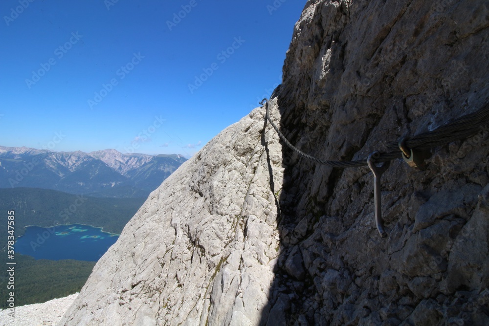Stahlseil am Fels über einem See in Bayern Stahlseil am Fels über einem See in Bayern