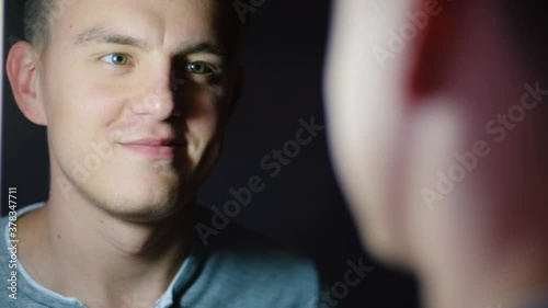 A man looking at himself in the mirror and tuning in to something important photo
