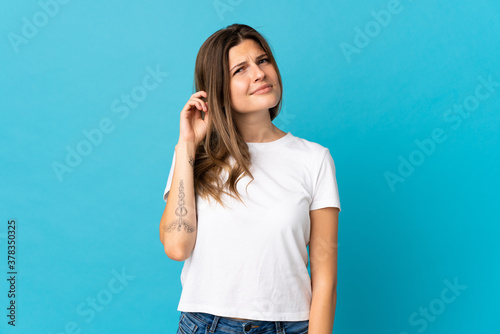 Young slovak woman isolated on blue background having doubts