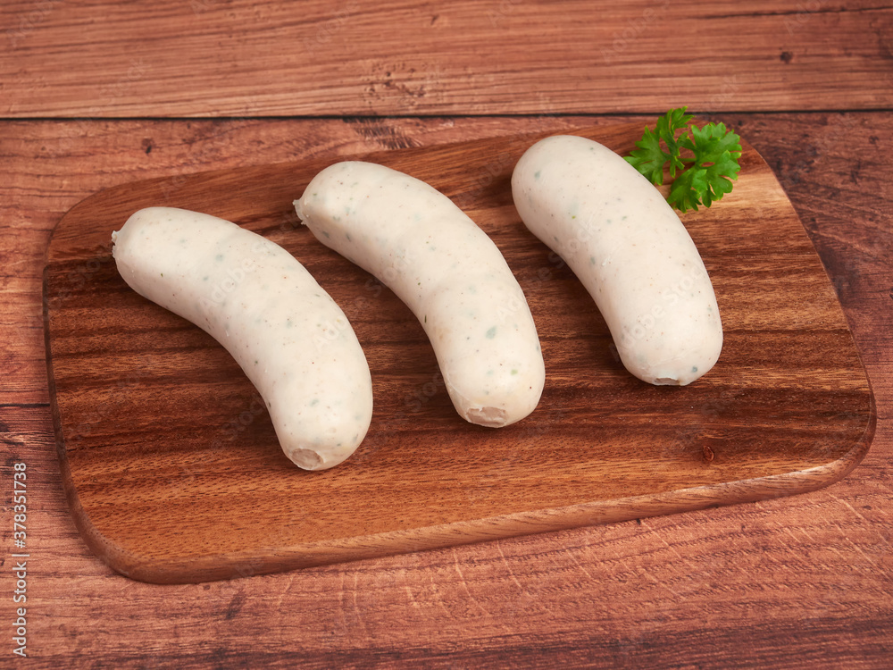 Bavarian white sausages (weisswurst) on a wooden board Bavarian white sausages (weisswurst) on a wooden board