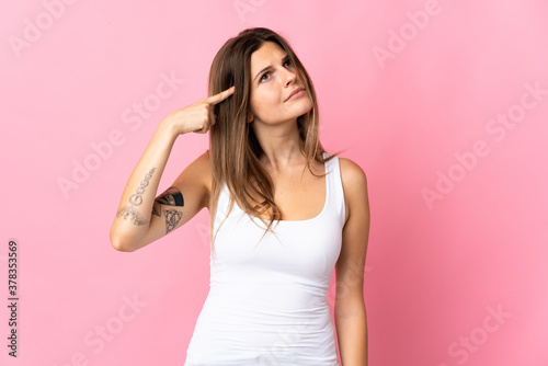Young slovak woman isolated on pink background making the gesture of madness putting finger on the head