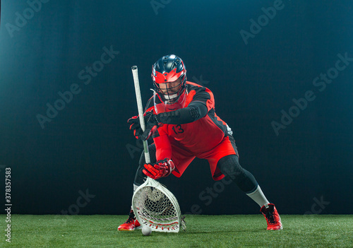 Lacrosse Player, athlete sportsman in red helmet on dark background. Sport and motivation wallpaper. photo
