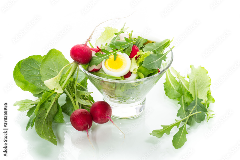 spring salad with arugula, boiled eggs, fresh radish, salad leaves in a glass bowl spring salad with arugula, boiled eggs, fresh radish, salad leaves in a glass bowl