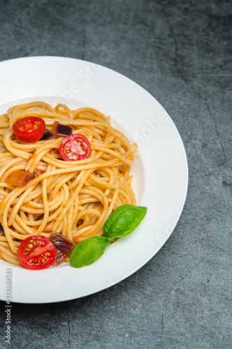 Tomato and mushroom spaghetti on a white plate