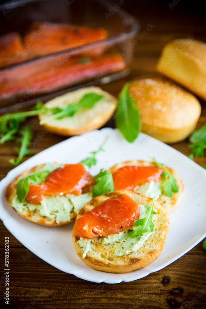 sandwich with fried bun, cheese spread and red fish in a plate