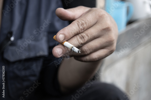 cigarette in man hand with smoke