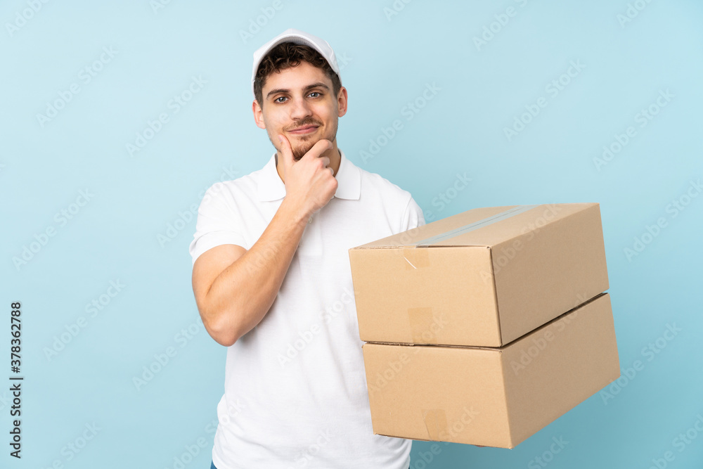 Delivery caucasian man isolated on blue background laughing Delivery caucasian man isolated on blue background laughing