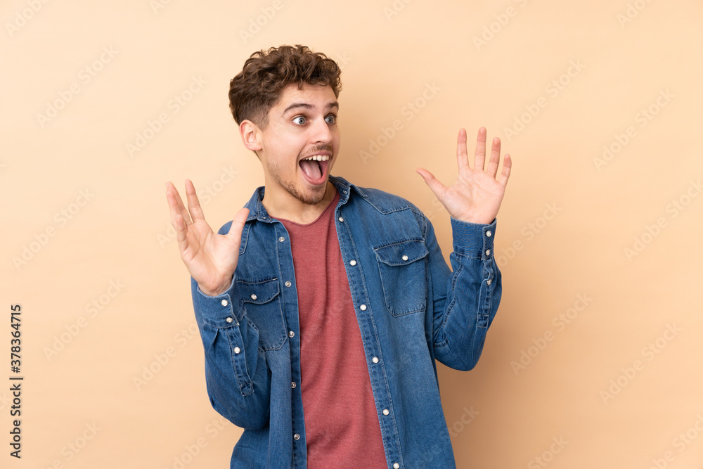 Caucasian man isolated on beige background with surprise facial expression Caucasian man isolated on beige background with surprise facial expression